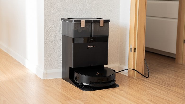 A black Ecovacs Deebot X8 Pro Omni robot vacuum cleaner docked at its charging station in a room. A black Ecovacs Deebot X8 Pro Omni robot vacuum cleaner docked at its charging station in a room.